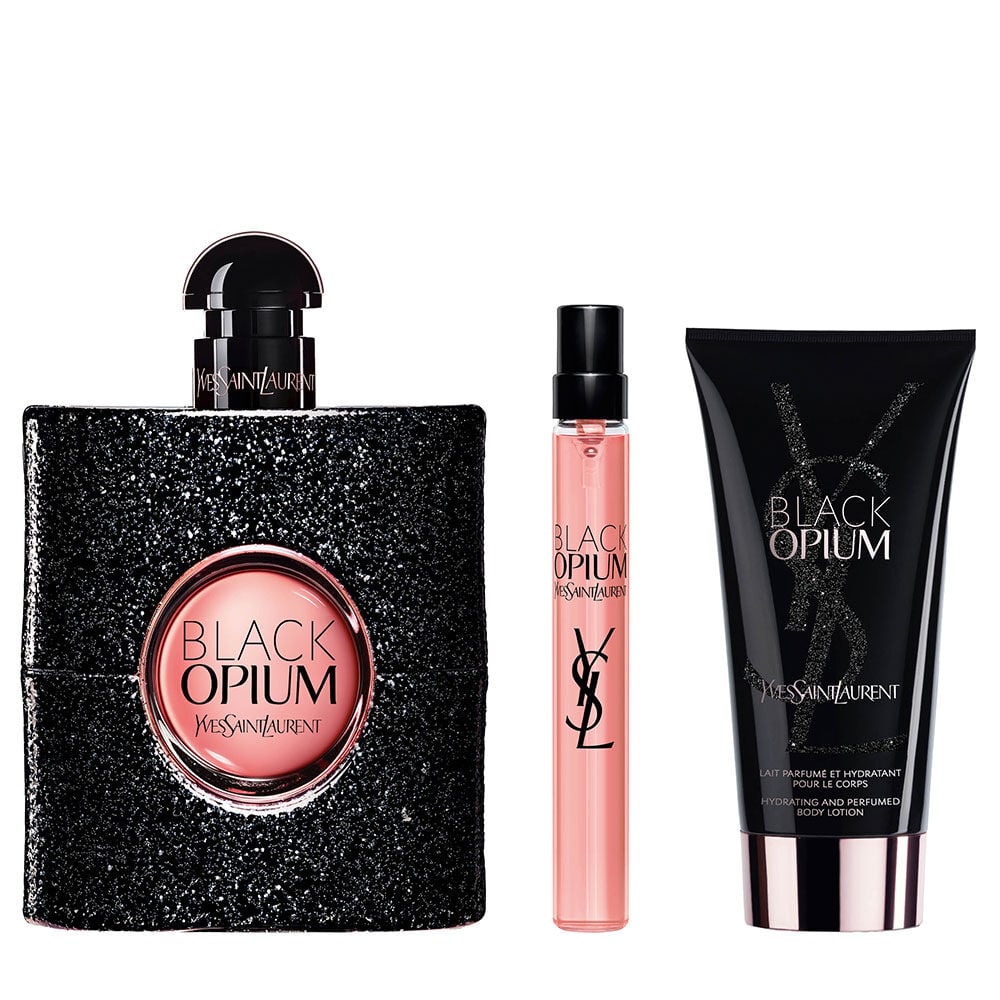 Frasco de Black Opium Eau de Parfum de 90 ml junto a un travel spray de 10 ml y un tubo de locion corporal (50 ml) sobre un fondo blanco.