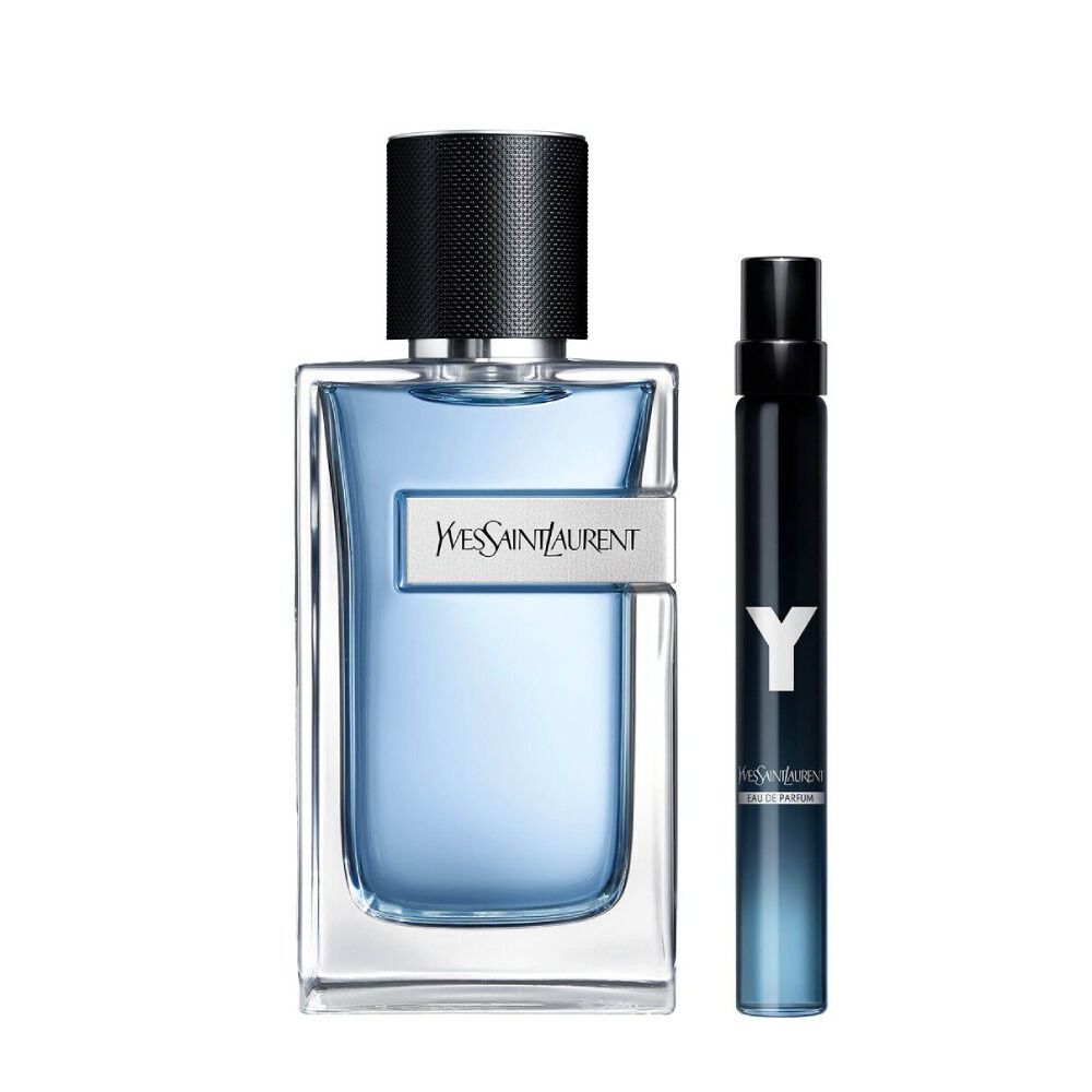 Botella de YSL Y Eau de Toilette de 100 ml con vidrio degradado azul junto a un spray de viaje a juego de 10 ml sobre fondo blanco.
