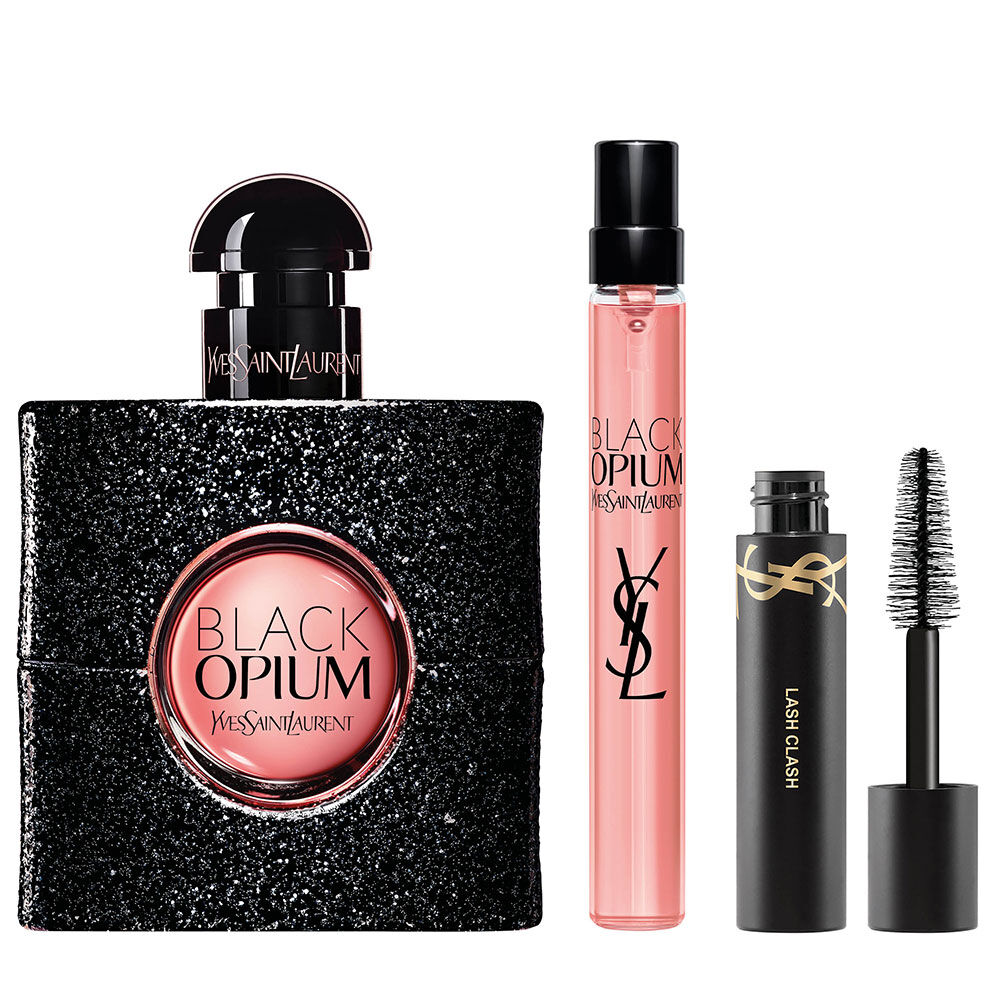 Botella de Black Opium Eau de Parfum de 50 ml junto a un formato de viaje de 10 ml y mini mascara de pestanas Lash Clash sobre fondo blanco.