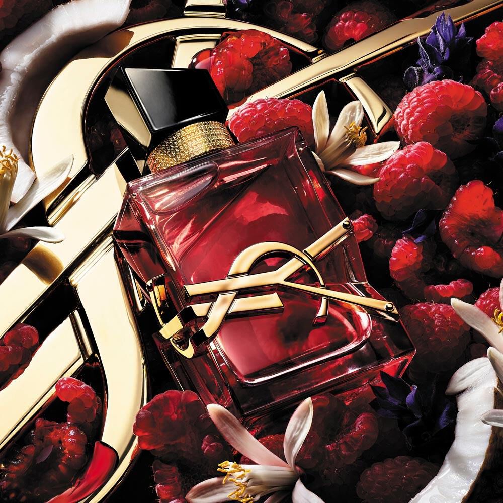 Perfume Libre de Yves Saint Laurent rodeado de frambuesas y flores blancas