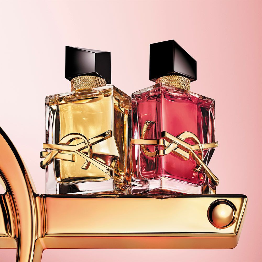 Dos frascos de perfume YSL Libre sobre fondo rosa y dorado