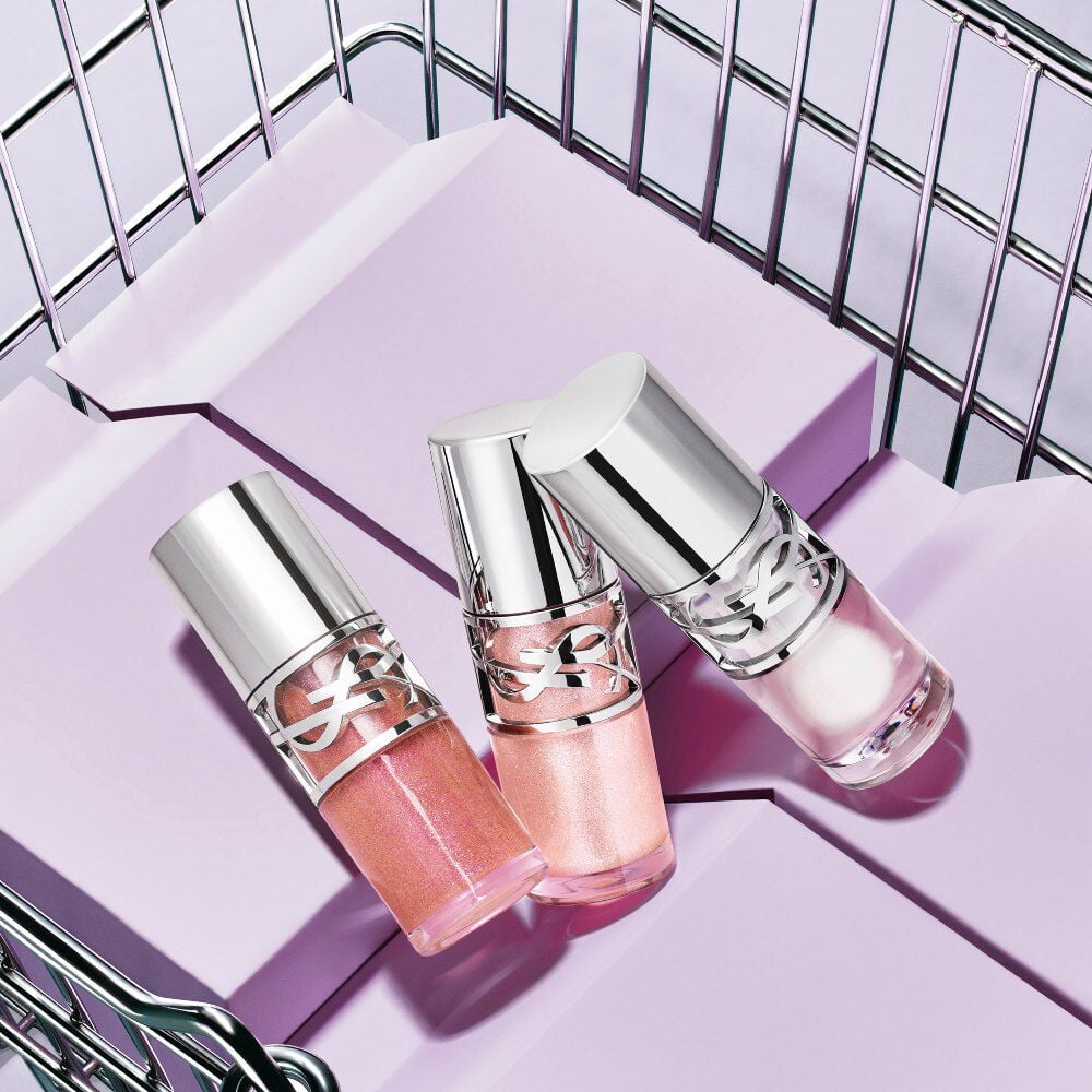Tres labiales YSL Loveshine en los tonos 10, 11 y 12 mostrados sobre bloques morados dentro de una canasta metálica.
