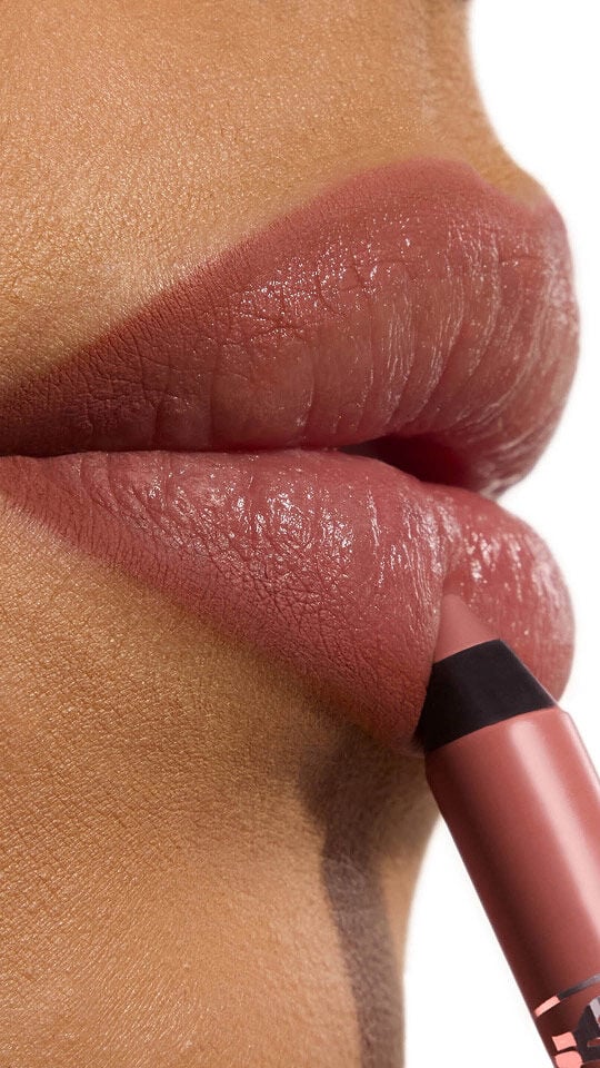 Ehlana aplicando YSL LOVENUDE Kiss Shaper en el tono 103, un primer plano de sus labios.