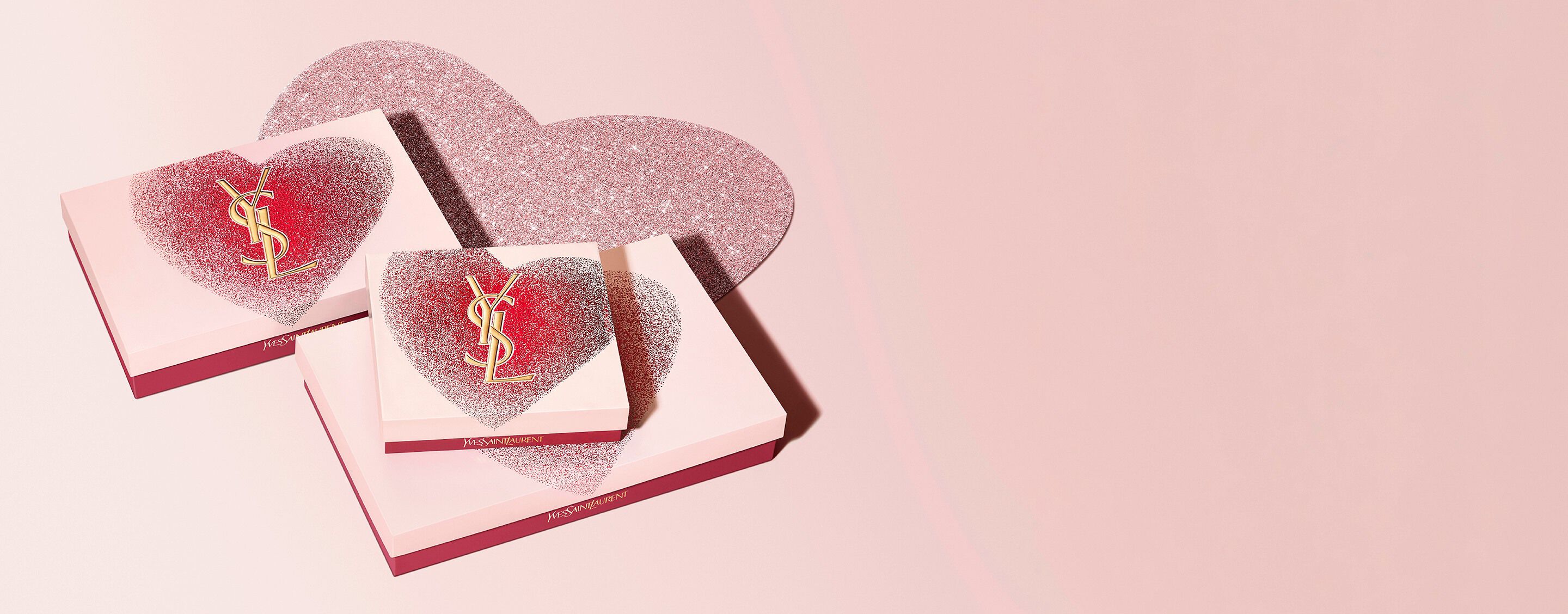 YSL Libre Eau de Parfum, a gold-toned bottle with
the YSL logo, on a glittery heart background.